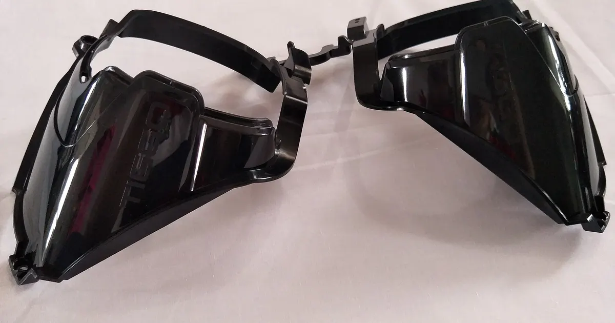 Black injection molded polycarbonate parts still joined at the runner, an example for an ABS vs PC enclosure choice